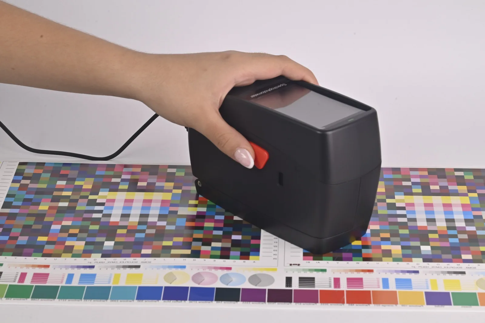 Operator holding the SpectroFit spectrodensitometer over a printed color chart